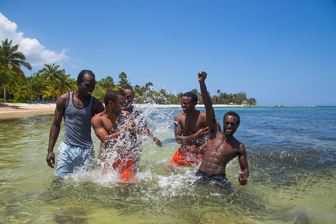 Guides spritzen mit Wasser nach Reitausflug für Gäste vom Half Moon Resort entlang Strand Sunrise Beach und ins Meer, Rose Hall, nahe Montego Bay, Saint James, Jamaika