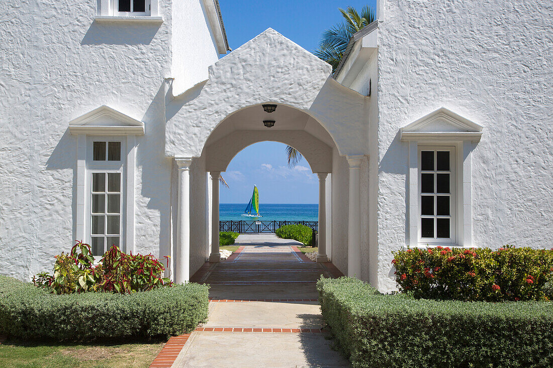 Entrance to villa at Royal Court of Half Moon Resort with Hobie Cat sailboat in Caribbean Sea behind Rose Hall, near Montego Bay, Saint James, Jamaica