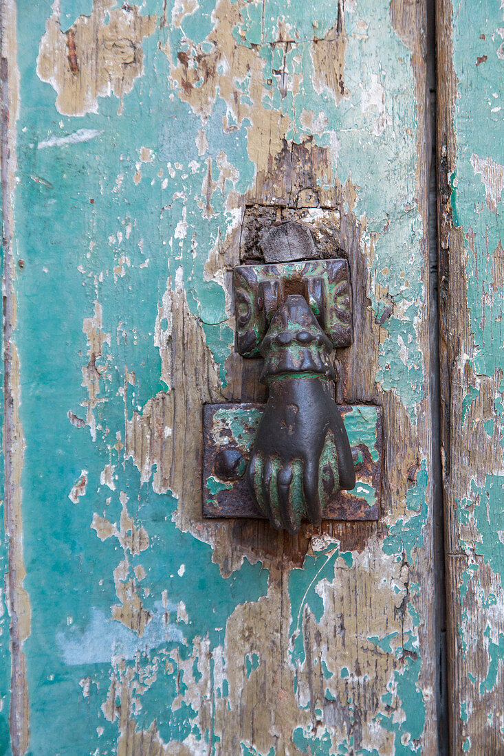 hand door-knocker on weathered door, peeling paint, nobody, Lisbon, Portugal