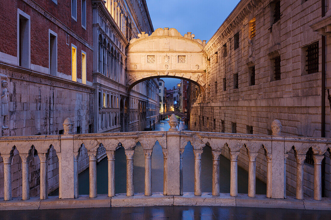 View from the Ponte della Paglia to Bridge of Sighs with the canal Rio del Palazzo in blue at night, San Marco, Venice, Veneto, Italy