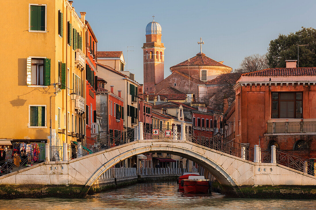Blick über den Canal Grande auf Häuser und die Kirche Chiesa di San Nicola da Tolentino am Kanal Rio Dei Tolentini mit Brücke in der Abendsonne, Santa Croce, Venedig, Venezien, Italien