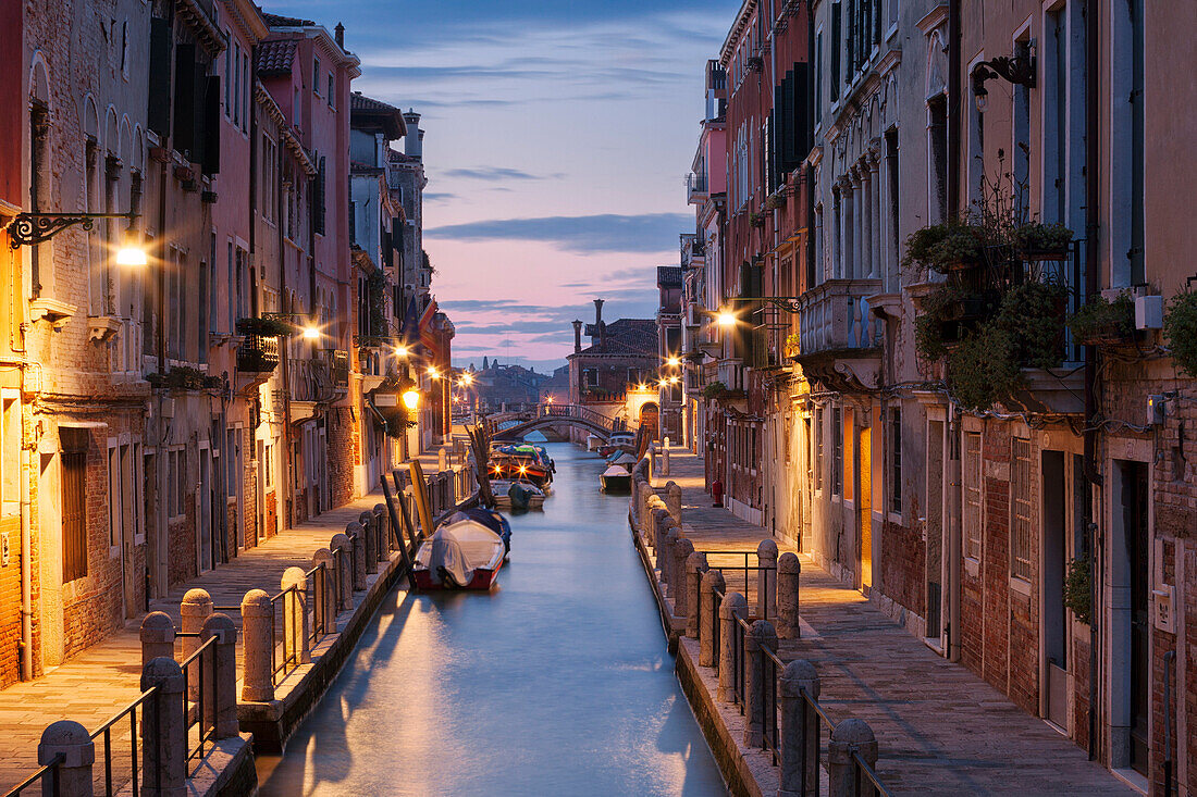Beleuchtete Häuser am Rio de la Fornace mit Booten in der Morgendämmerung, Dorsoduro, Venedig, Venezien, Italien