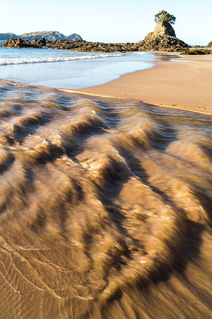Fluss strömt ins Meer, gegenläufige Strömung, unberührt, brauner Sand, Brandung, Hochformat, Tauranga Bay, Northland, Nordinsel, Neuseeland