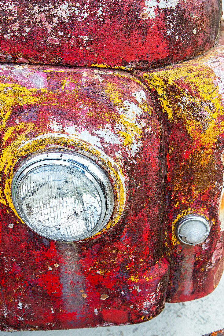 detail headlight of rusting old car, abandoned, red, yellow paint, South Island, New Zealand
