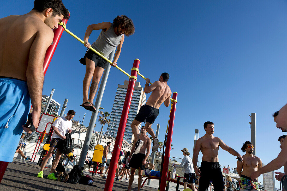 Young men excersizing on the beach, Tel-Aviv, Israel