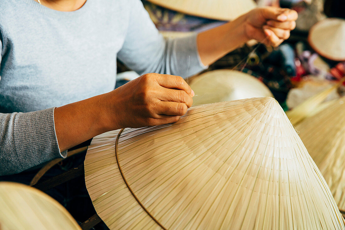 Close up of artisan weaving straw hat