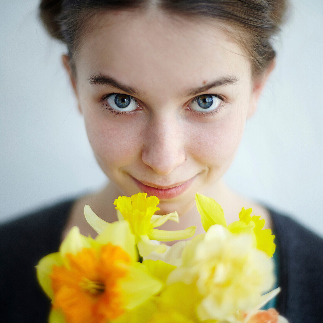 Smiling Caucasian girl holding yellow flowers