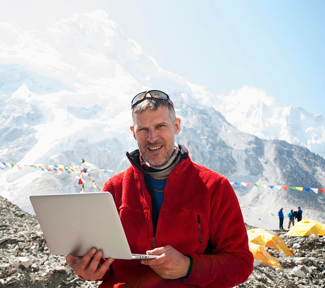Man using laptop on snowy mountain