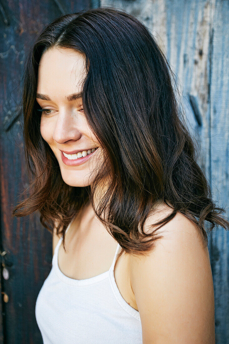 Smiling Caucasian woman near wooden fence