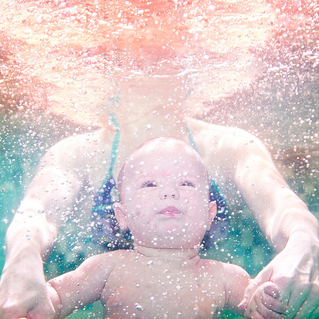 Caucasian mother and preschooler son swimming underwater