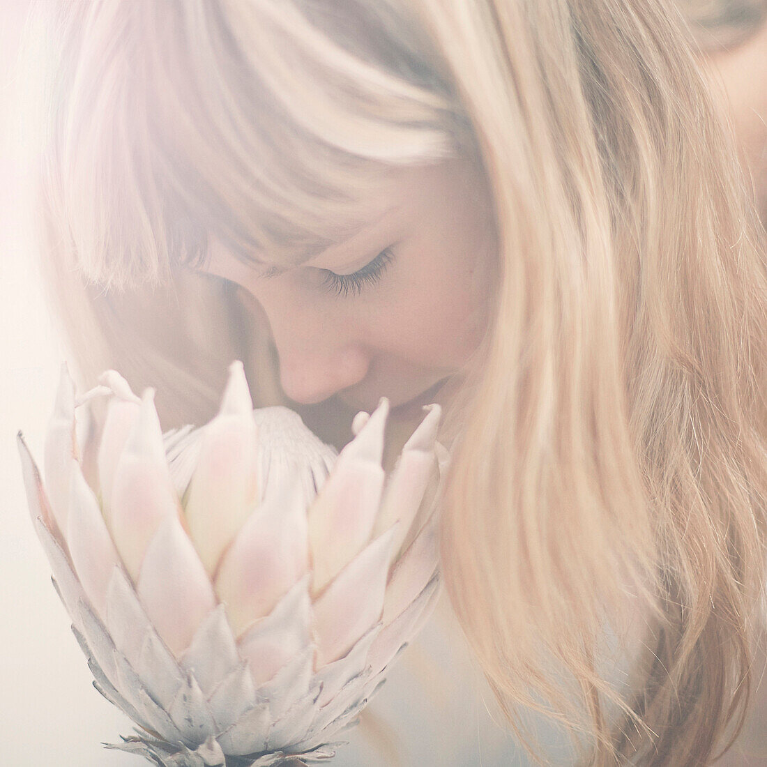 Caucasian teenage girl smelling flower