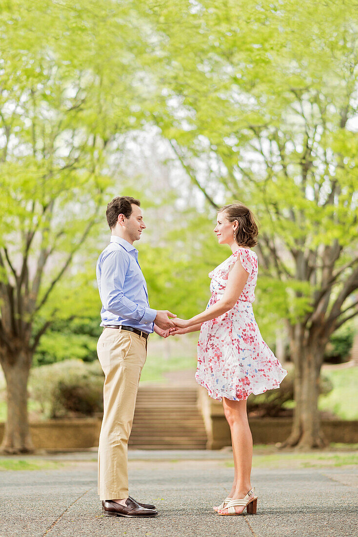 Pregnant Caucasian couple holding hands outdoors