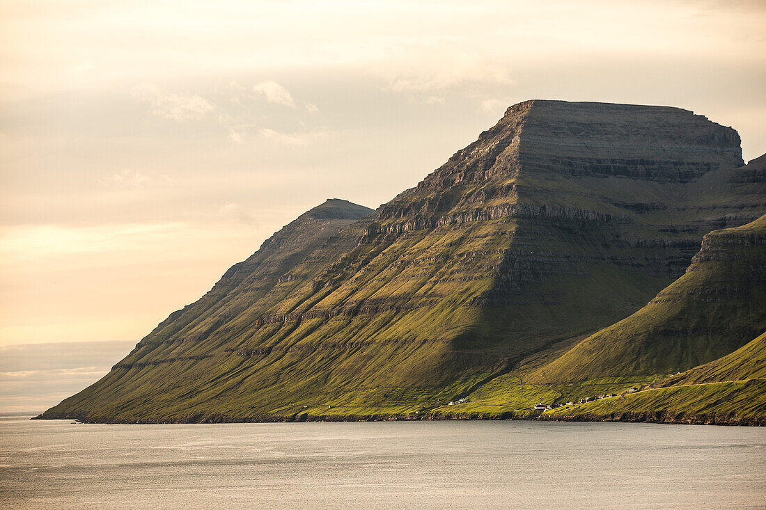 Wunderschöner grün bewachsener Berg am Meer, Färöer Inseln