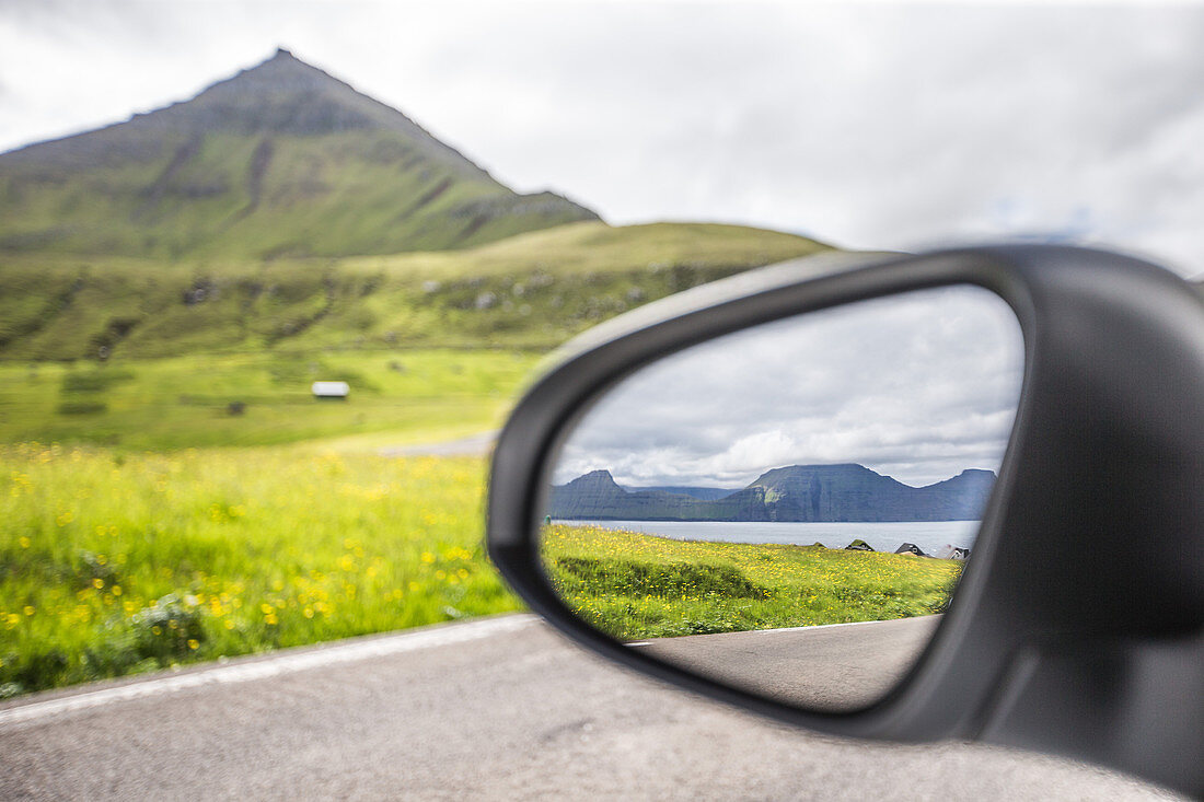 Blick vom Seitenspiegel eines Autos auf die wundervolle Landschaft, Färöer Inseln