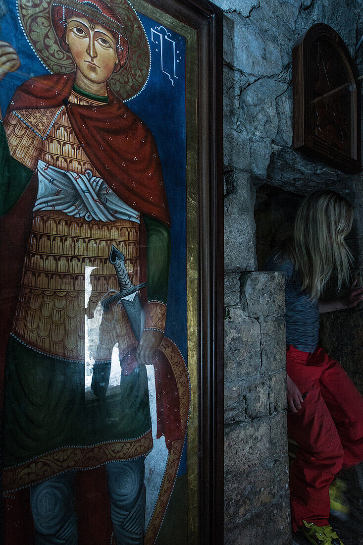 Young woman in a small church next to a image of a saint, Gudauri, Mtskheta-Mtianeti, Georgia