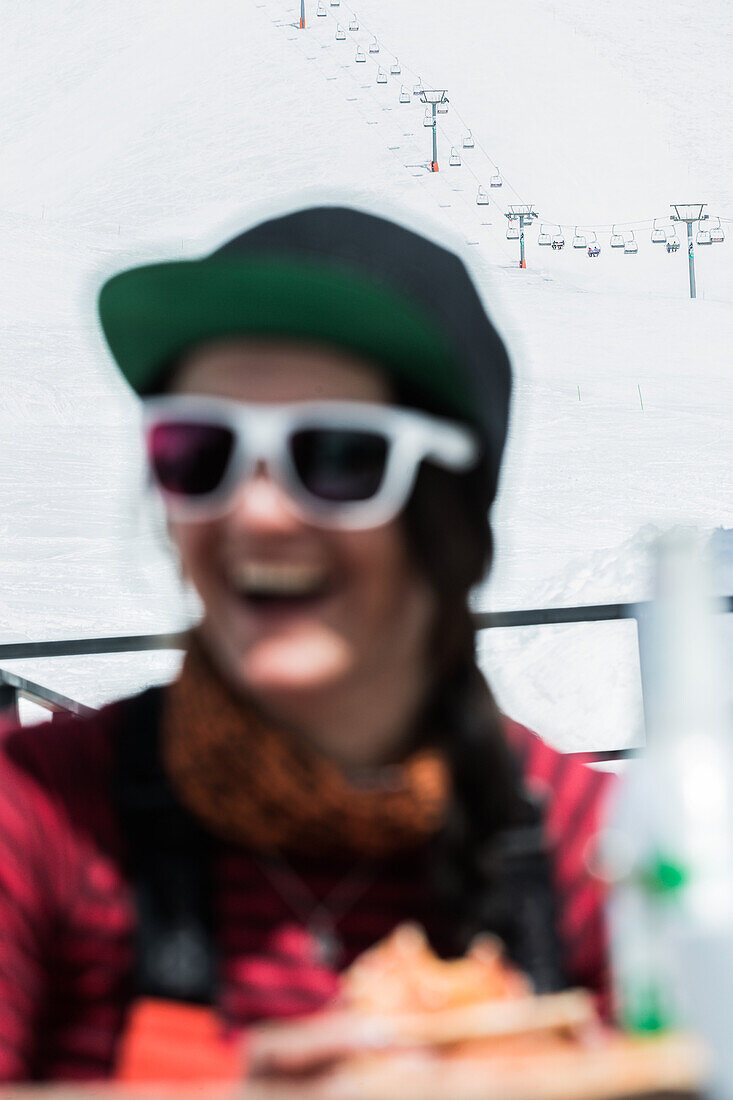 Young female skier sitting at a ski hut in the near of an chairlift, Gudauri, Mtskheta-Mtianeti, Georgia