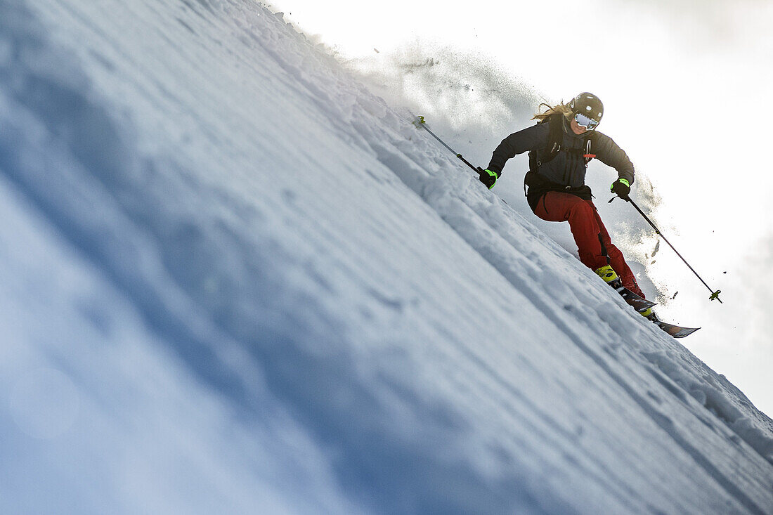 Young female skier riding apart the slopes through the deep powder snow, Gudauri, Mtskheta-Mtianeti, Georgia