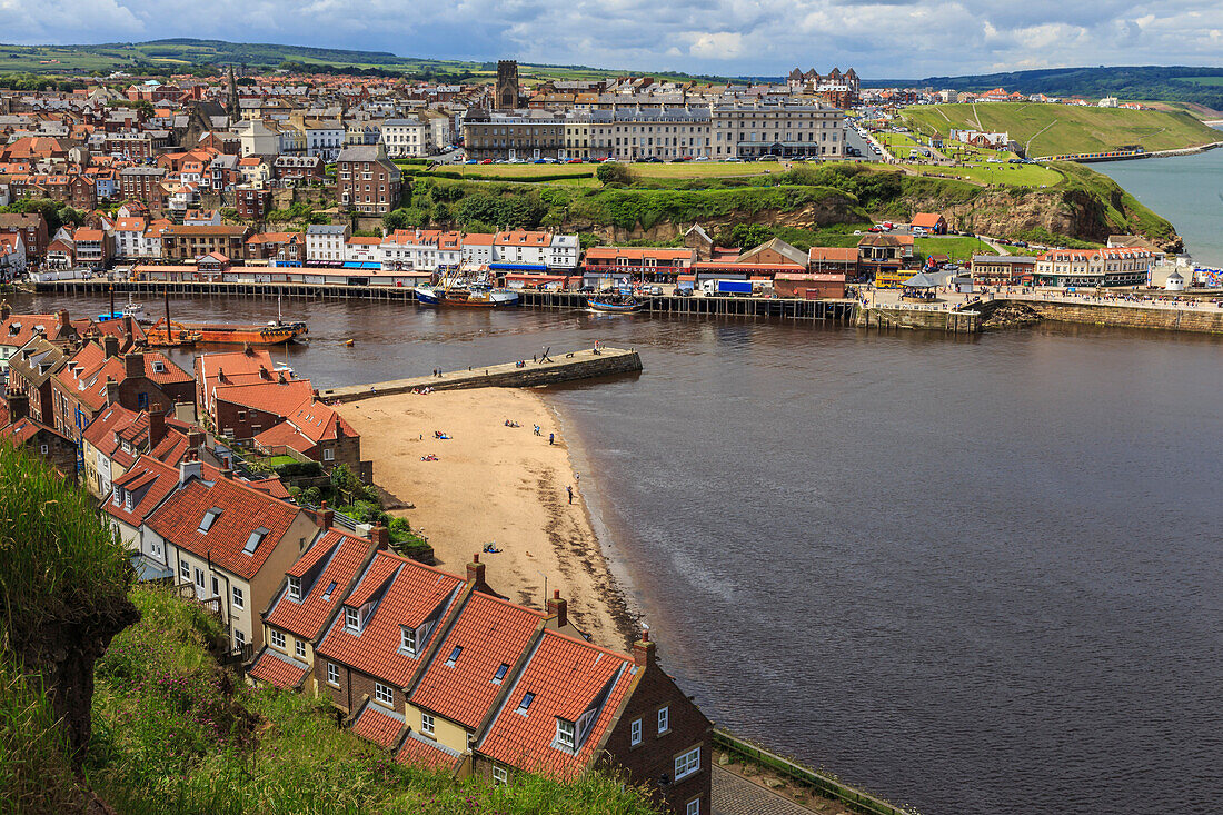 Tate Hill Beach, red roofed houses, town on West Cliff with backdrop of green hills in summer, Whitby, North Yorkshire, England, United Kingdom, Europe