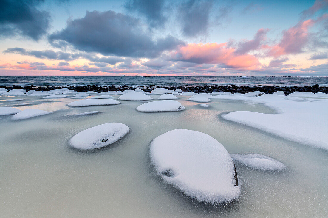 Dämmerung auf dem kalten Meer umgeben von schneebedeckten Felsen geprägt von Wind und Eis am Eggum, Vestvagoy (Vest-Vagoy) Insel, Lofoten Inseln, Arktis, Norwegen, Skandinavien, Europa