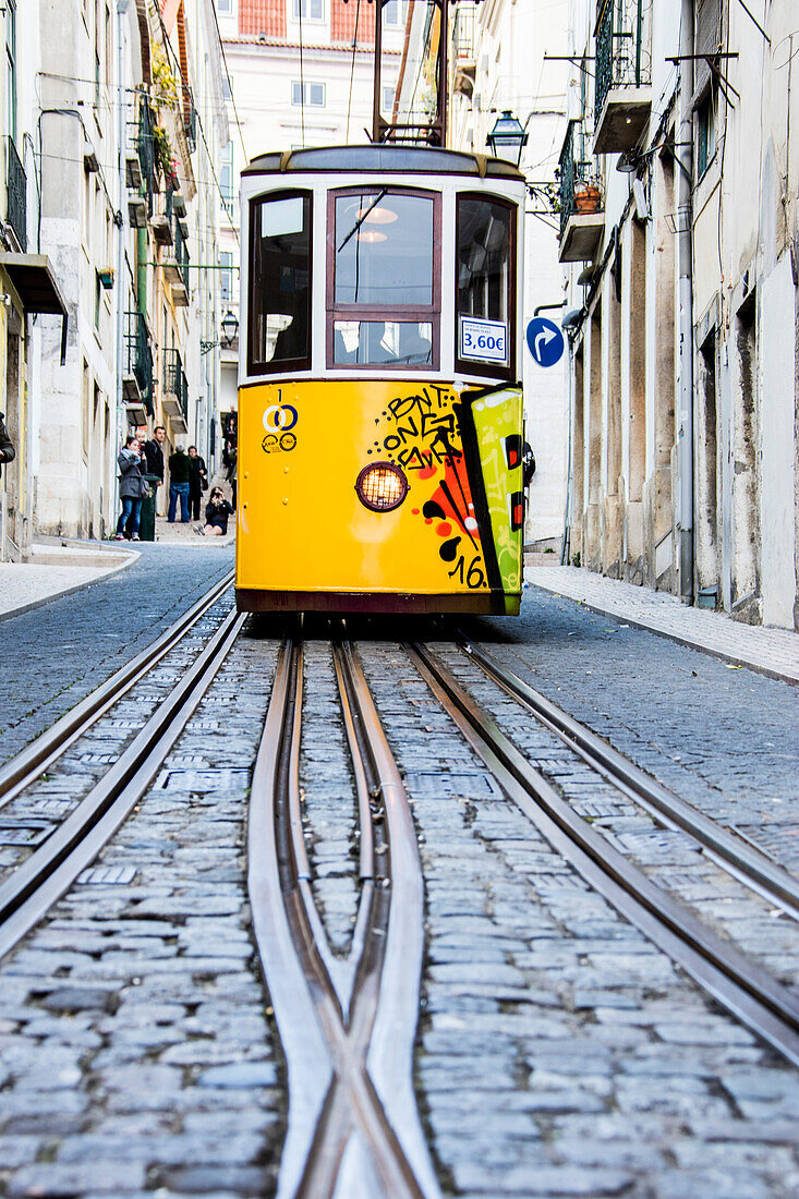 The characteristic yellow tram proceeds towards Bairro Alto, a central district of the old city of Lisbon, Portugal, Europe