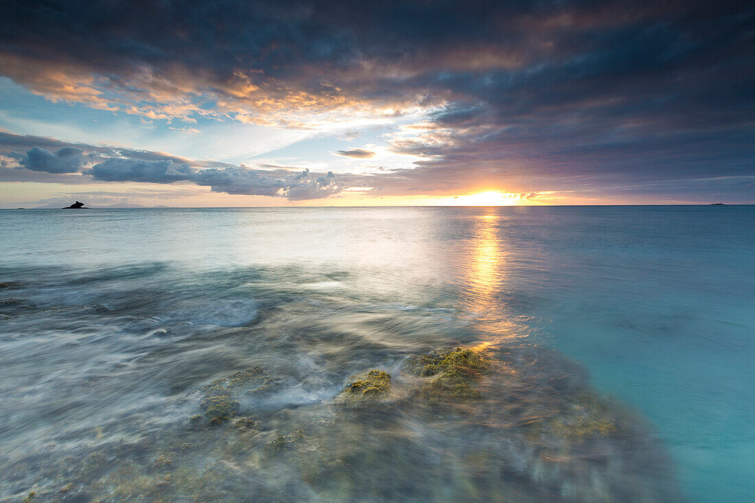 Die Lichter des Sonnenuntergangs spiegeln sich im blauen Meer, Hawksbill Bay, Antigua, Antigua und Barbuda, Leeward Islands, Westindische Inseln, Karibik, Mittelamerika