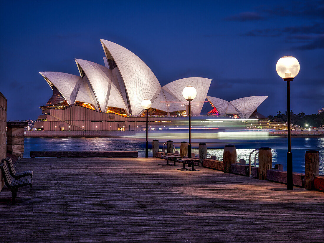 Ein Boot geht durch die Sydney Opera House, UNESCO Weltkulturerbe, während der blauen Stunde, Sydney, New South Wales, Australien, Pazifik