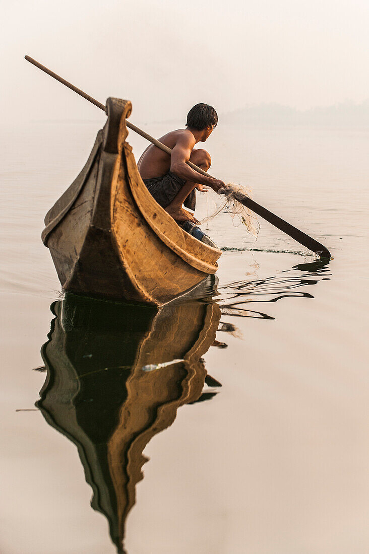 Ein Fischer zieht in seinem Netz auf Indawgyi See in Kachin Staat, Myanmar (Birma), Asien