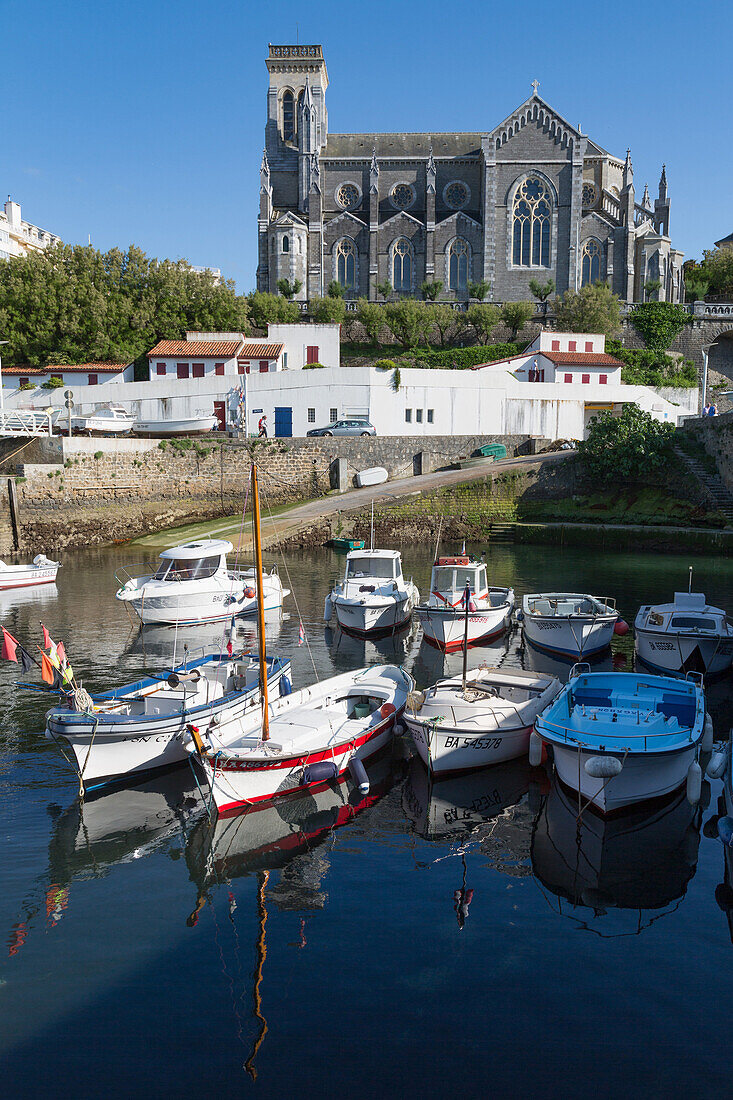 Small port with traditional fishing boats and Eglise Sainte Eugenie in Biarritz, Pyrenees Atlantiques, Aquitaine, France, Europe