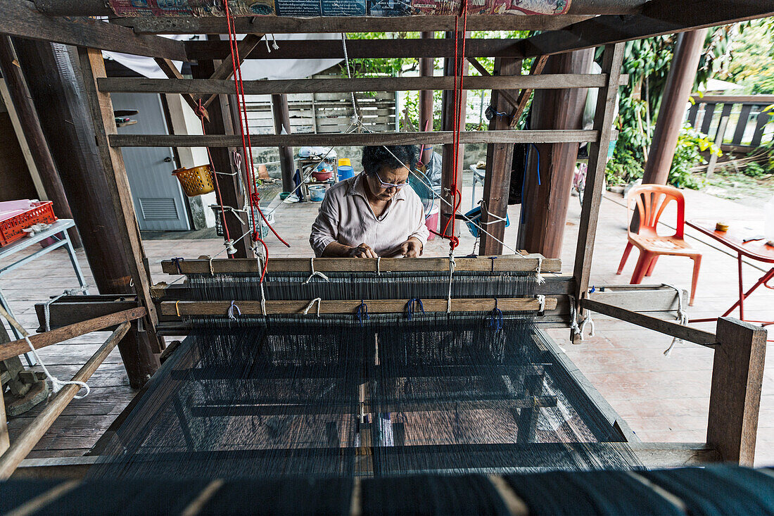 Tai Lue (Lu) indigenous weaver at a wooden loom weaving Tai Lue traditional clothing, Chiang Mai, Thailand, Southeast Asia, Asia