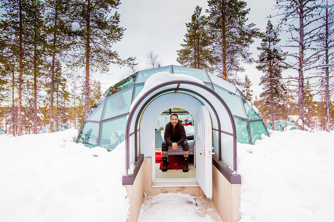 Mann sitzt im Iglu, Kakslauttanen Iglu-Dorf, Saariselka, Finnland, Skandinavien, Europa