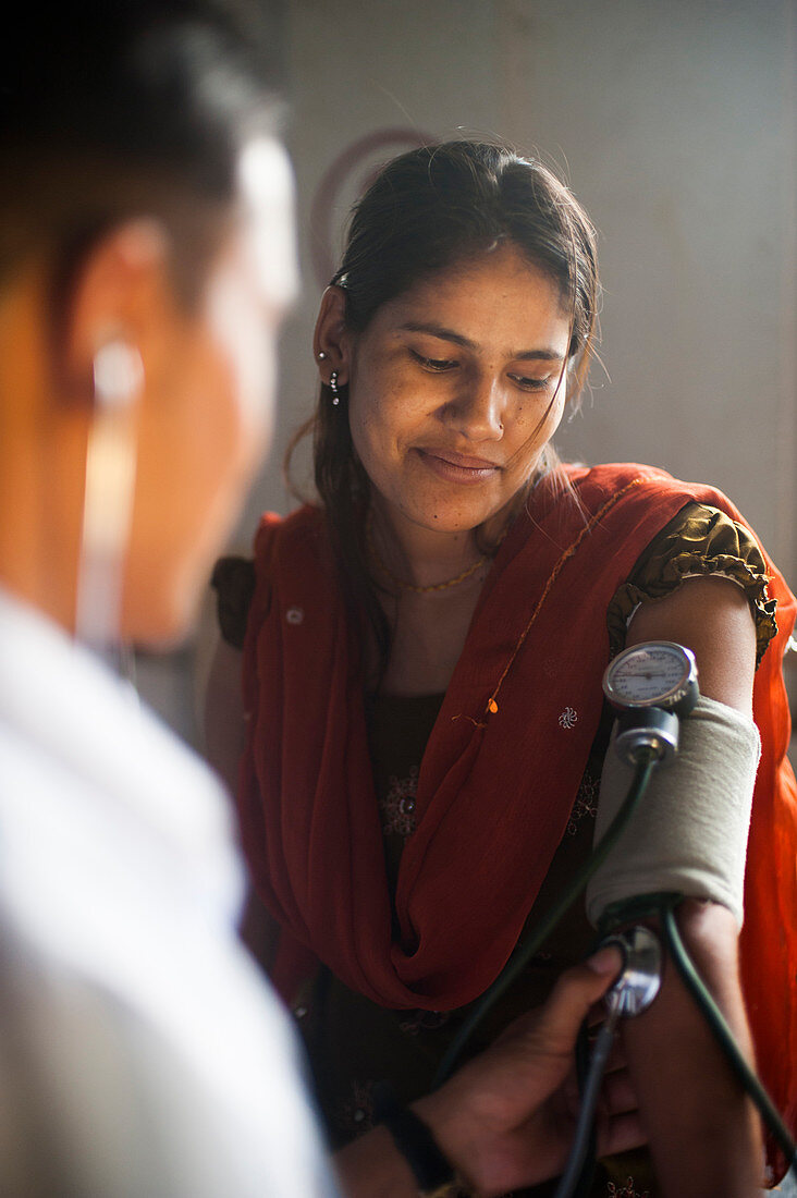 Ein Arzt nimmt den Blutdruck einer Frau in einem Krankenhaus in Nepal, Asien