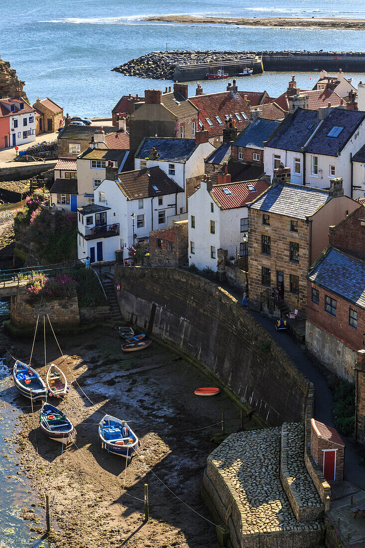 Winding alleys of village, fishing boats and sea, elevated view in summer, Staithes, North Yorkshire Moors National Park, Yorkshire, England, United Kingdom, Europe