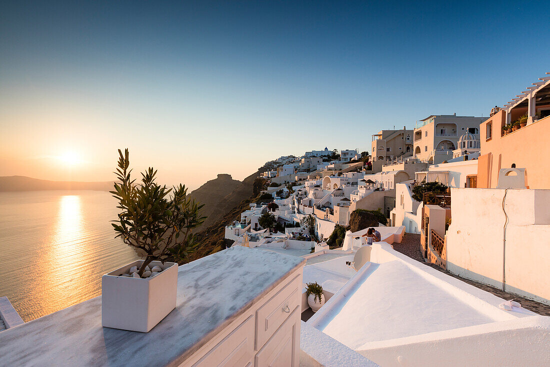 Sunset over the Aegean Sea seen from a terrace of the typical Greek village of Firostefani, Santorini, Cyclades, Greek Islands, Greece, Europe