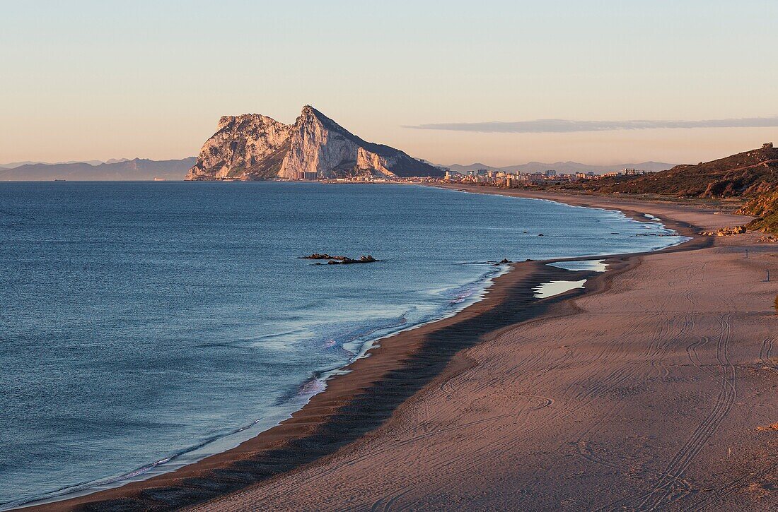The Rock of Gibraltar (British) and the town of La Linea de la Concepcion seen from the Mediterranean coast north of it. In the background the coastline of Morocco. In the early morning. Cadiz province, Andalusia, Spain.