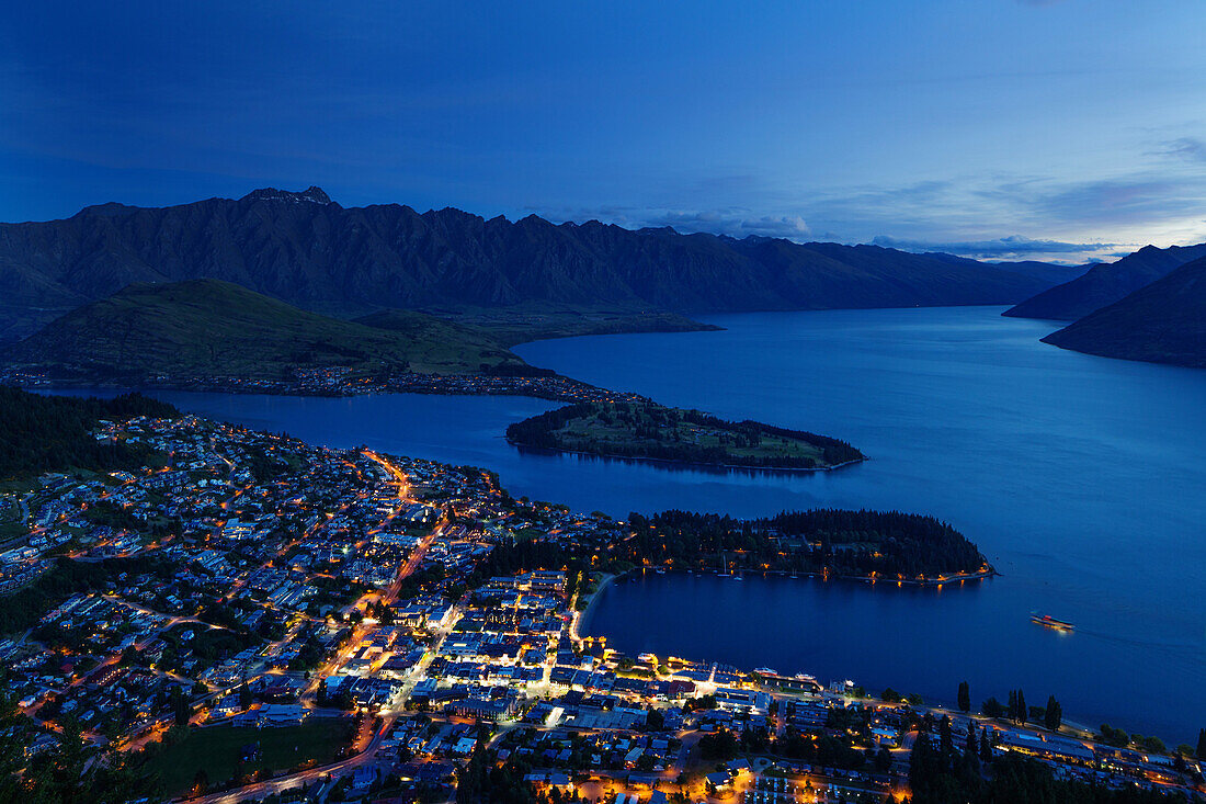 Queenstown at dusk on the shore of Lake Wakatipu with the Remarkables mountain range beyond, Otago, South Island, New Zealand, Pacific