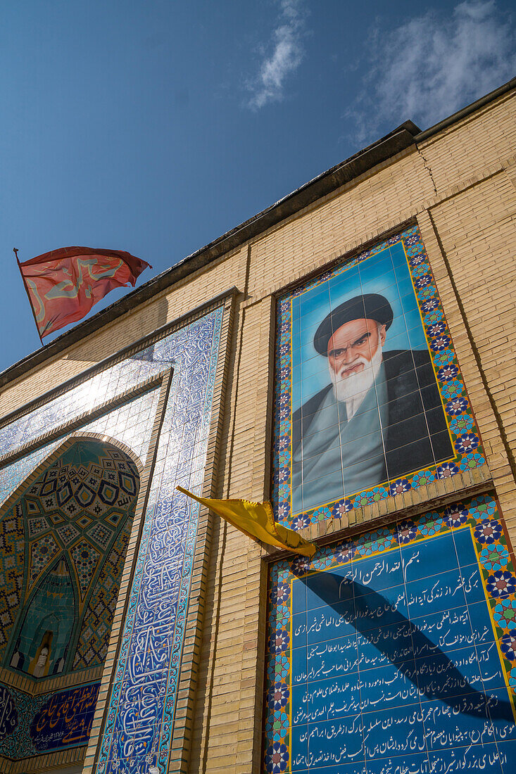 Imam Khomeini looks down from the facade of a small mosque in the backstreets, Shiraz, Iran, Middle East