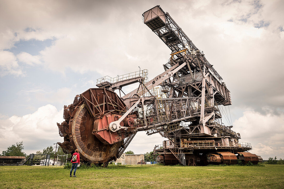 woman in front of bucket-wheel excavator ''Big Wheel'' at Ferropolis - City of Iron, Dessau, Saxony-Anhalt, European Route of Industrial Culture