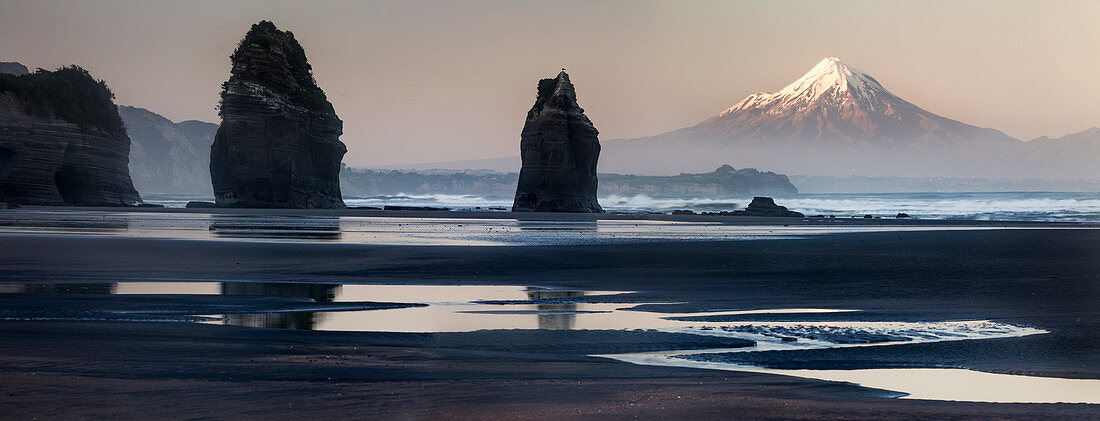 Rock formations and view of Mount Taranaki volcano, Tongaporutu, Taranaki, North Island, New Zealand, Oceania