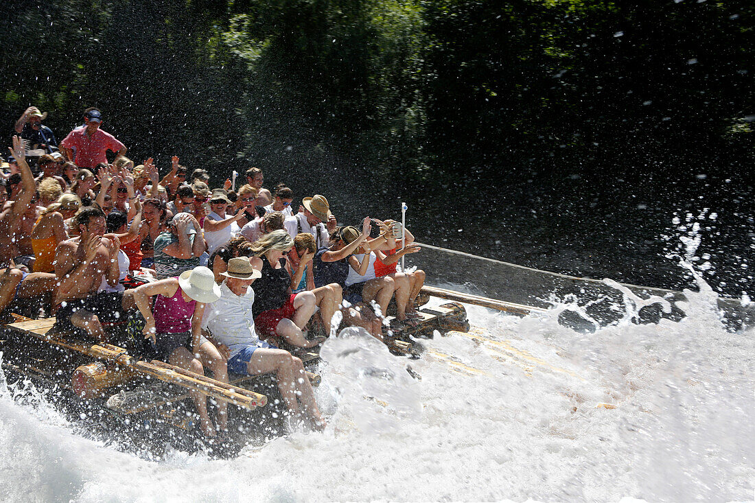 People on a traditional wooden raft on a shute in Thalkirchen, Munich, Upper Bavaria, Bavaria, Germany