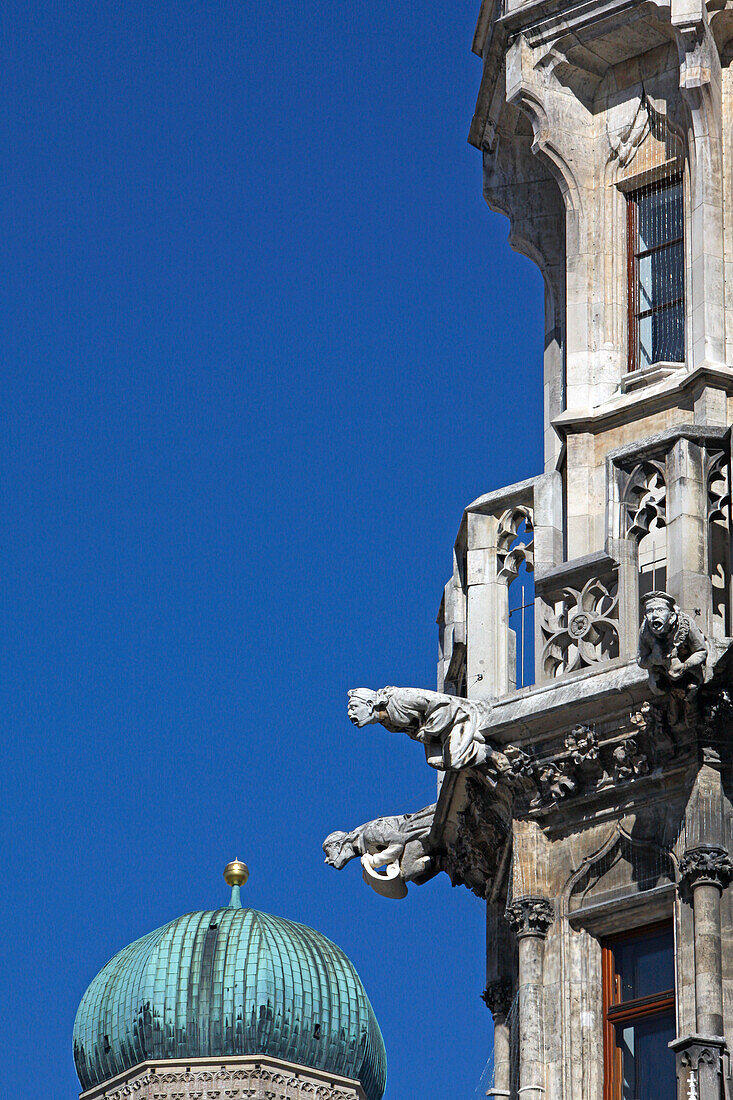 Gargoyles at the facade of the New city hall and one of the steeple tops of Frauenkirche, Marienplatz, Munich, Upper Bavaria, Bavaria, Germany