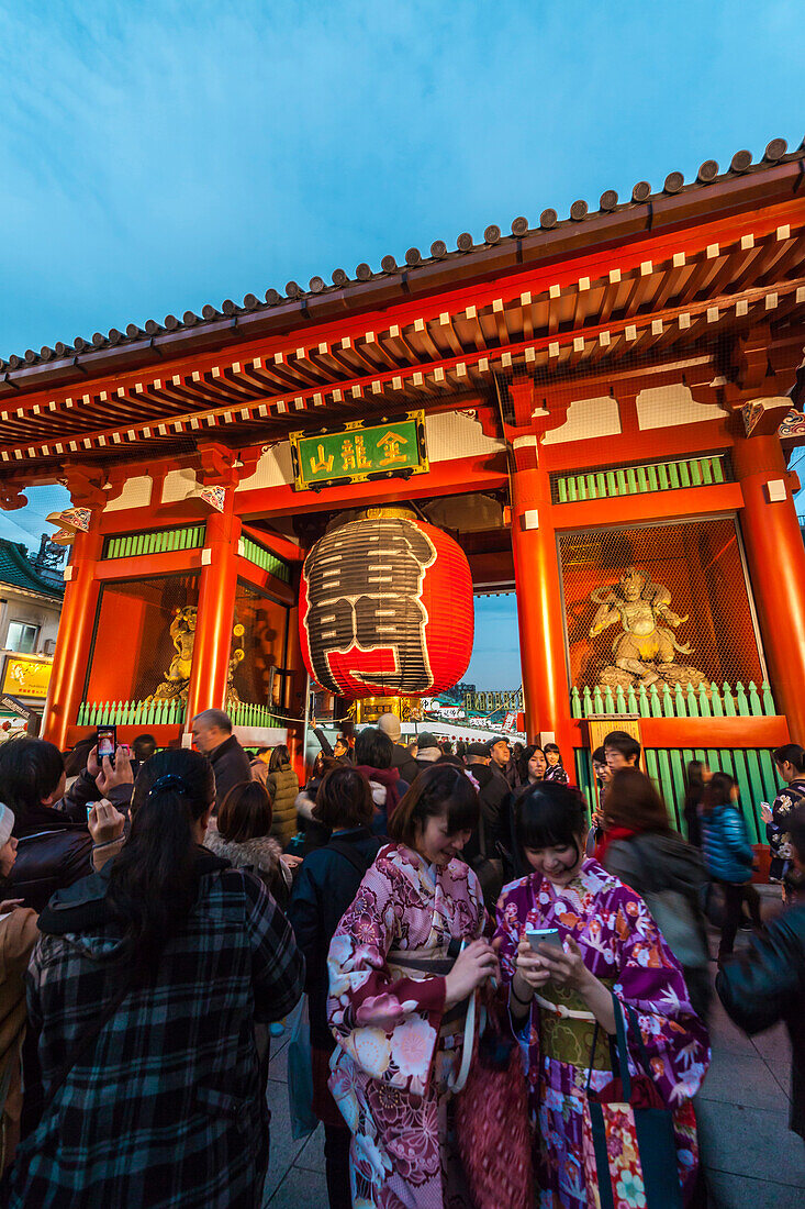 Junge Asiatinnen bekleidet mit Kimono machen Selfies vorm Kaminari-mon in Asakusa, Taito-ku, Tokio, Japan