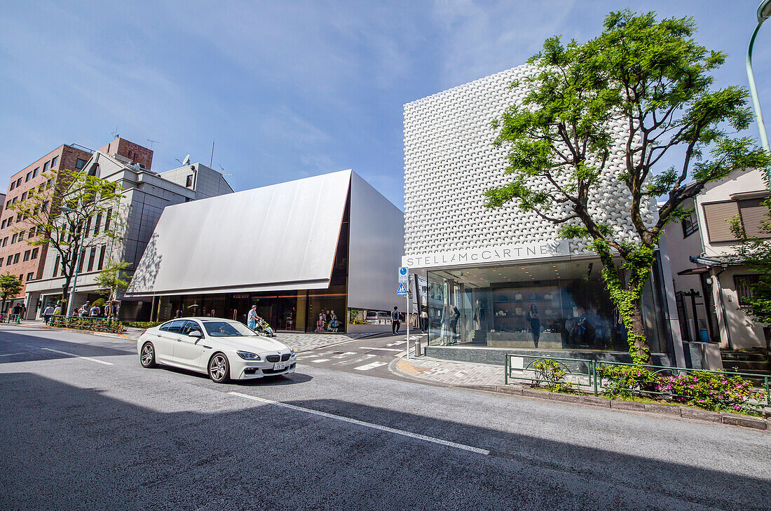 Einkaufsstraße mit Luxusgeschäften und Auto in Aoyama, Minato-ku, Tokio, Japan