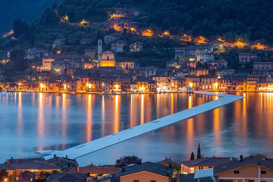 The Floating Piers and Peschiera Maraglio at dusk in Iseo Lake - Italy, Europe.