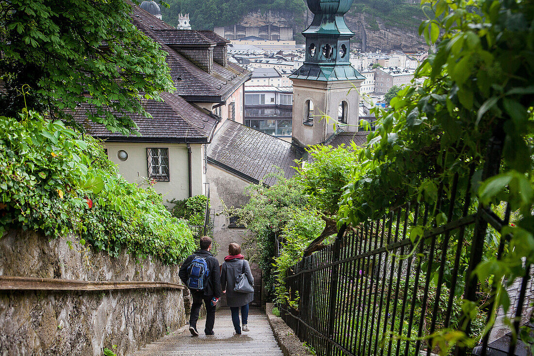 Stairs of Imbergstiege and belltower of St. Johannes am Imberg, way to the top of Kapuzinerberg, Salzburg, Austria.