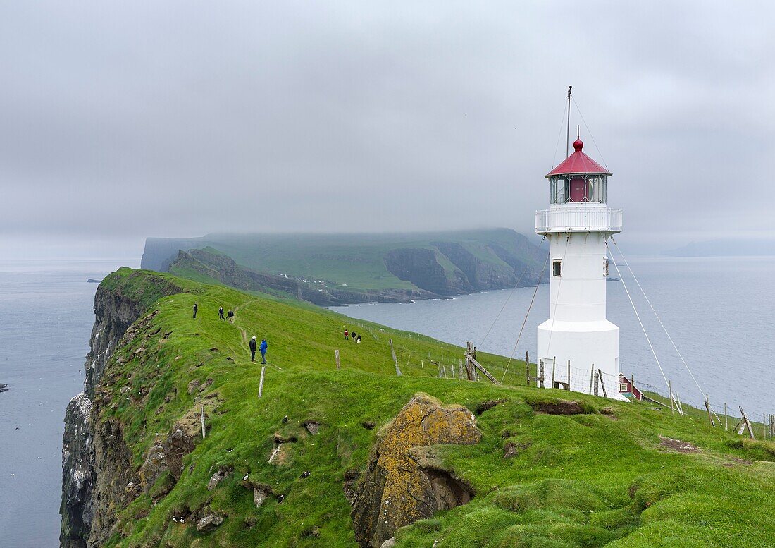 The lighthouse on Mykinesholmur. The island Mykines, part of the Faroe Islands in the North Atlantic. Europe, Northern Europe, Denmark, Faroe Islands.