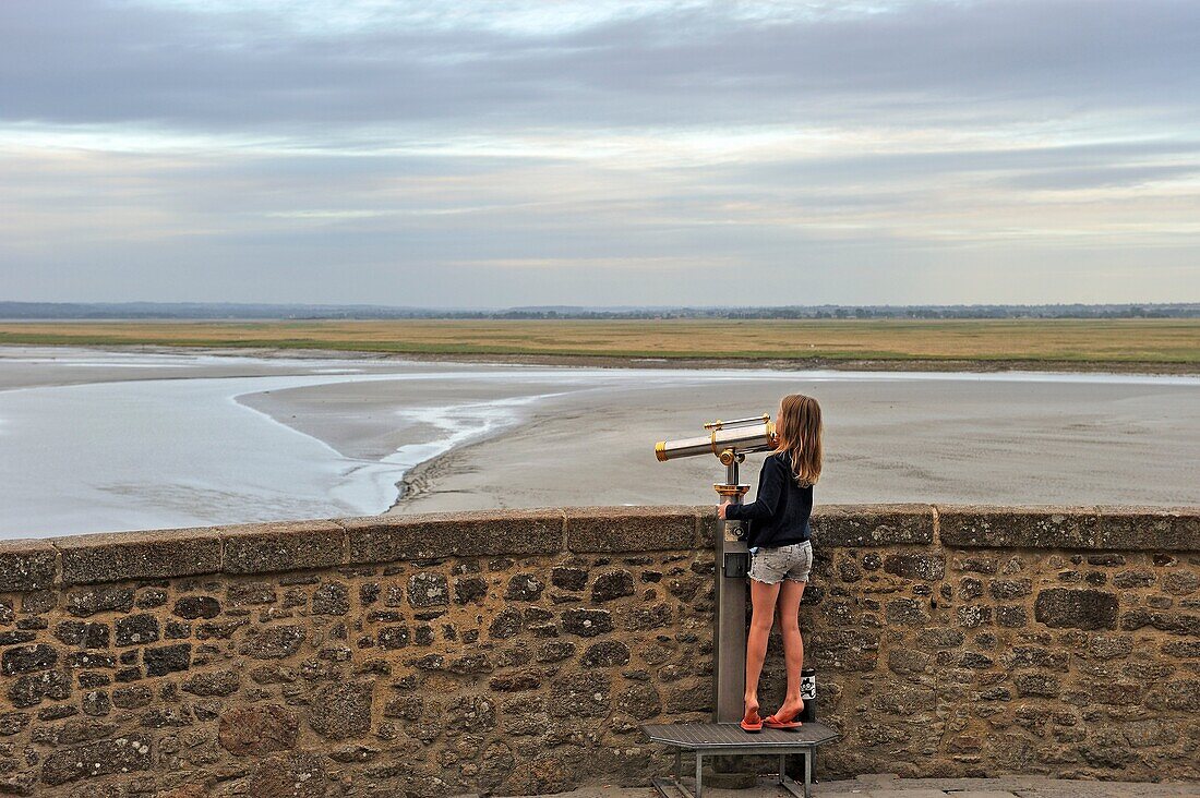 kleines Mädchen schaut durch ein Teleskop, Bucht von Mont-Saint-Michel, Departement Manche, Region Normandie, Frankreich, Europa.