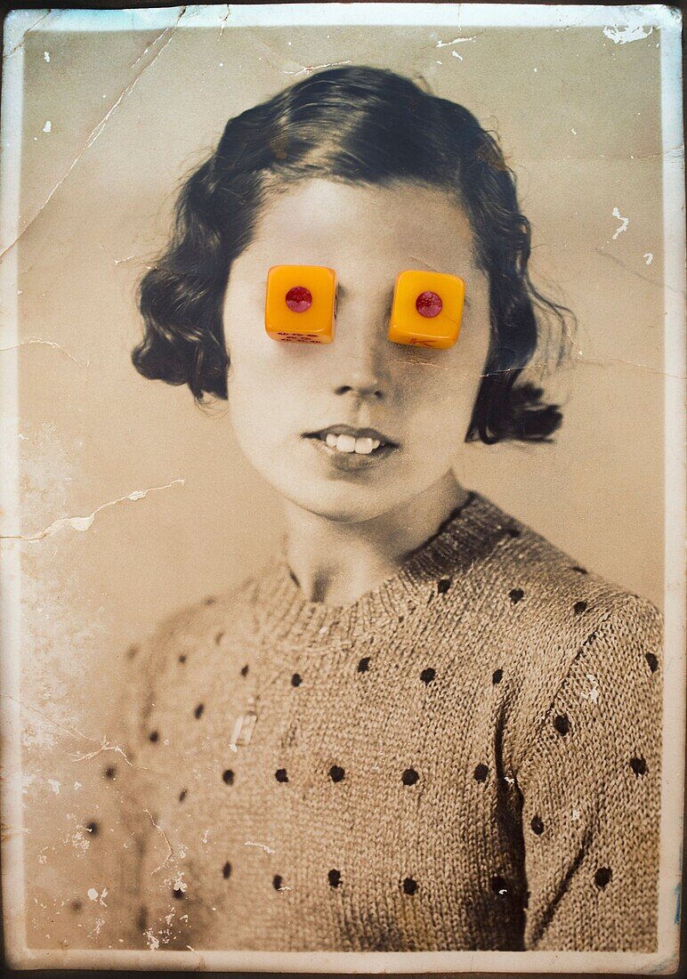 Old black and white portrait of woman looking at camera with dice on her eyes