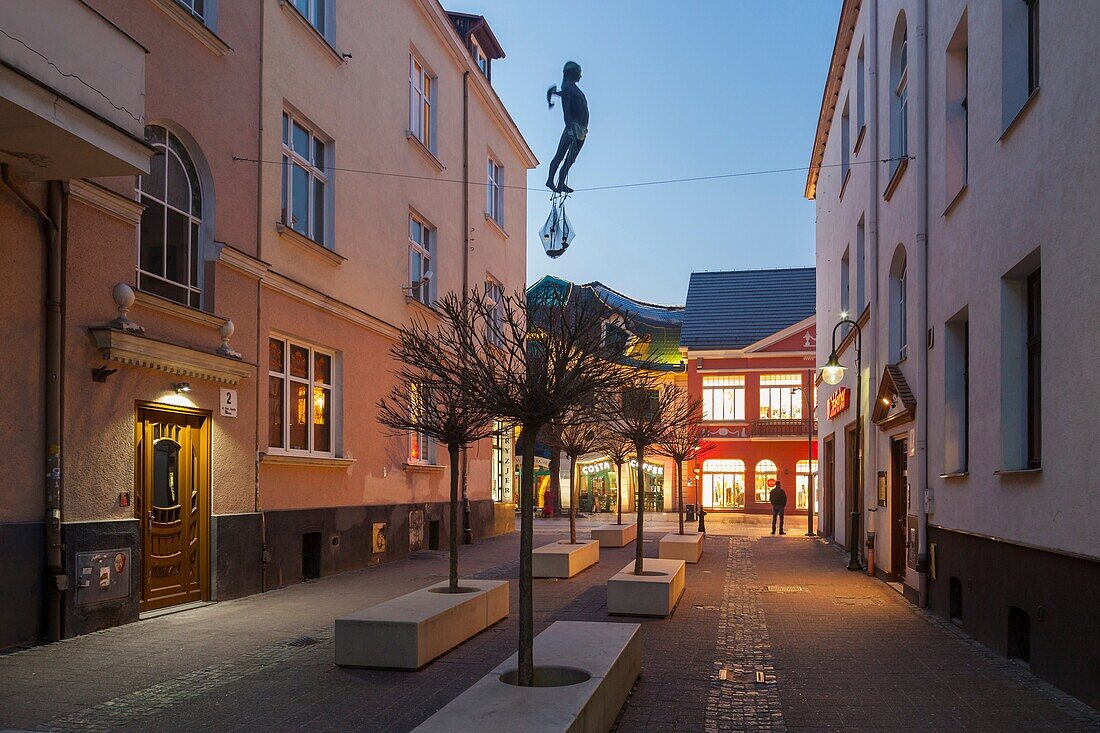 Evening on Bem street in Sopot town centre, Poland. The Fisherman statue balancing on the line between buildings.