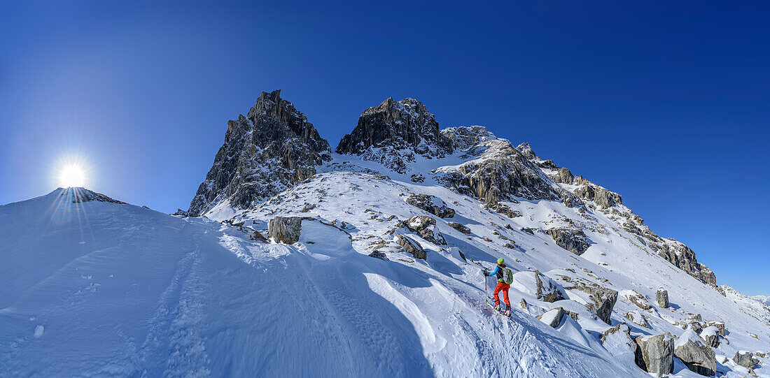 Panorama with woman backcountry skiing ascending towards Geier, Lizumer Reckner in background, Geier, Tuxer Alps, Tyrol, Austria
