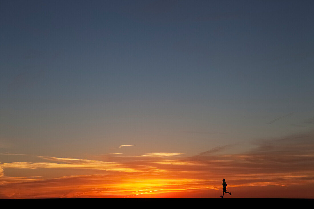 'Man jogging at sunrise; Chicago, Illinois, United States of America'